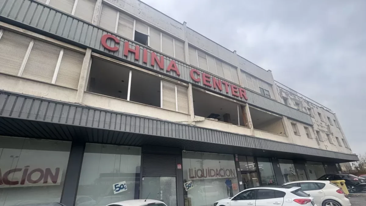 Fachada del edificio, con carteles de liquidación en la tienda y ventanas arrancadas en el primer piso. - MARC CARBONELL