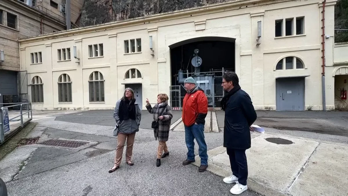 Terence Lyster, con abrigo rojo, ayer en las instalaciones de la central de Camarasa. - ARIADNA SÁNCHEZ / NOGUERA TV