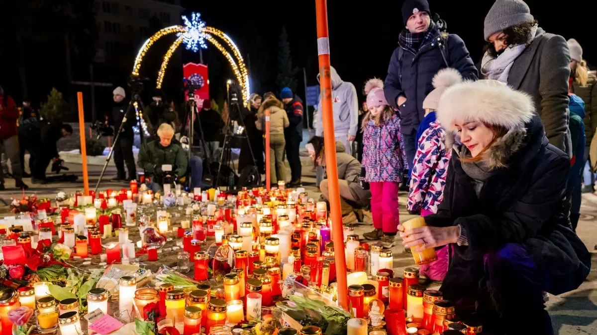 Diverses persones deixen espelmes al memorial de les víctimes de Crans-Montana. - EFE/EPA/JEAN-CHRISTOPHE BOTT