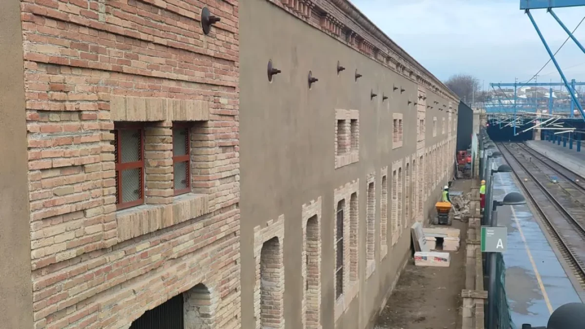 Al fons, operaris treballant en la façana dels Docs que dona a les vies. - JMA