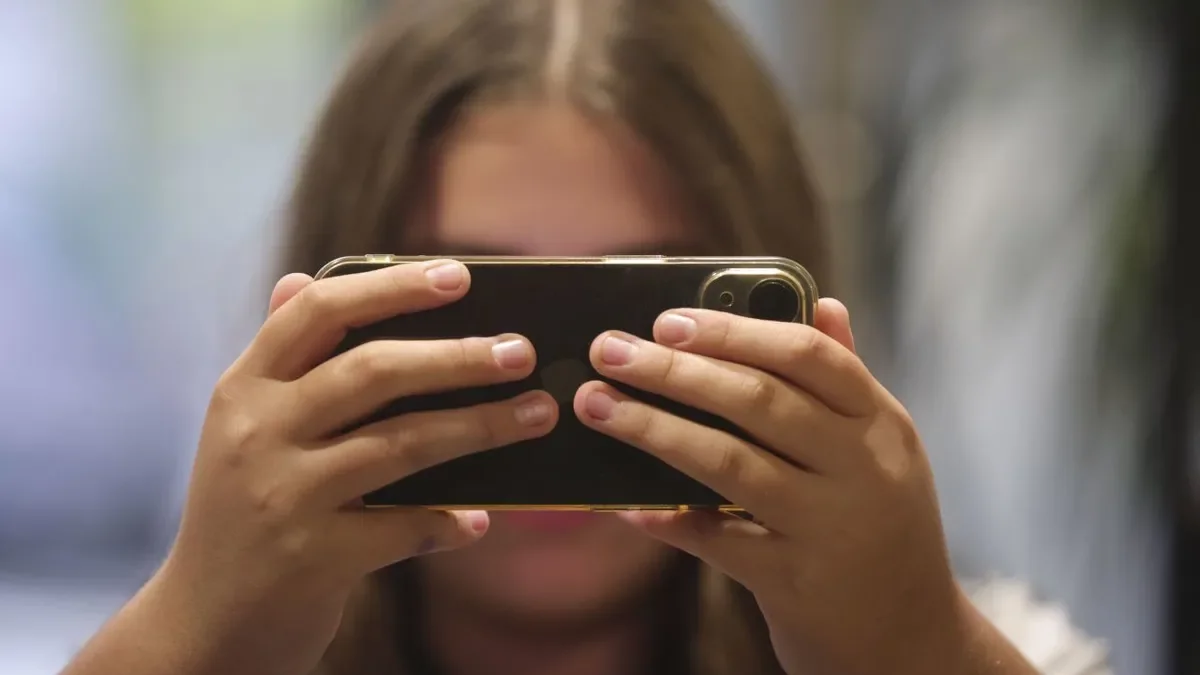 Imatge d’arxiu d’una nena consultant el telèfon mòbil. - EFE