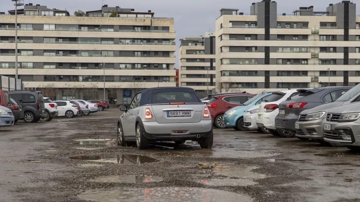 Un cotxe circulant pel solar que funciona com a pàrquing darrere del col·legi Frederic Godàs. - JORDI ECHEVARRIA