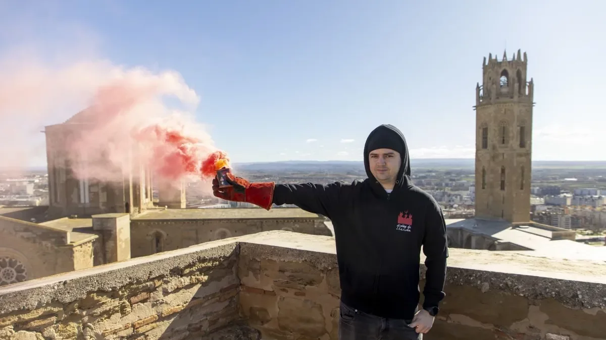 Un dels participants encén una bengala al Castell del Rei. - JORDI ECHEVARRIA