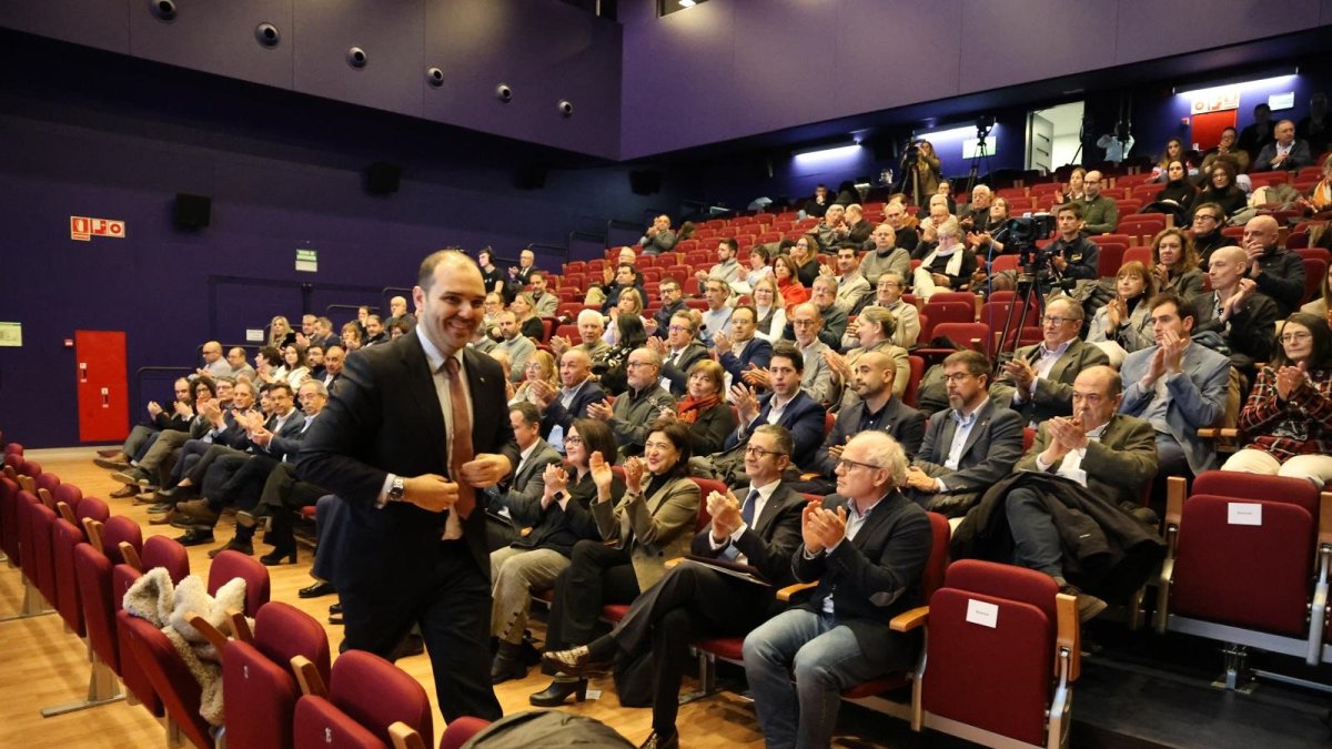 El conseller Albert Dalmau, dirigiéndose al escenario de la sala La Lira de Tremp, donde se celebra la jornada.