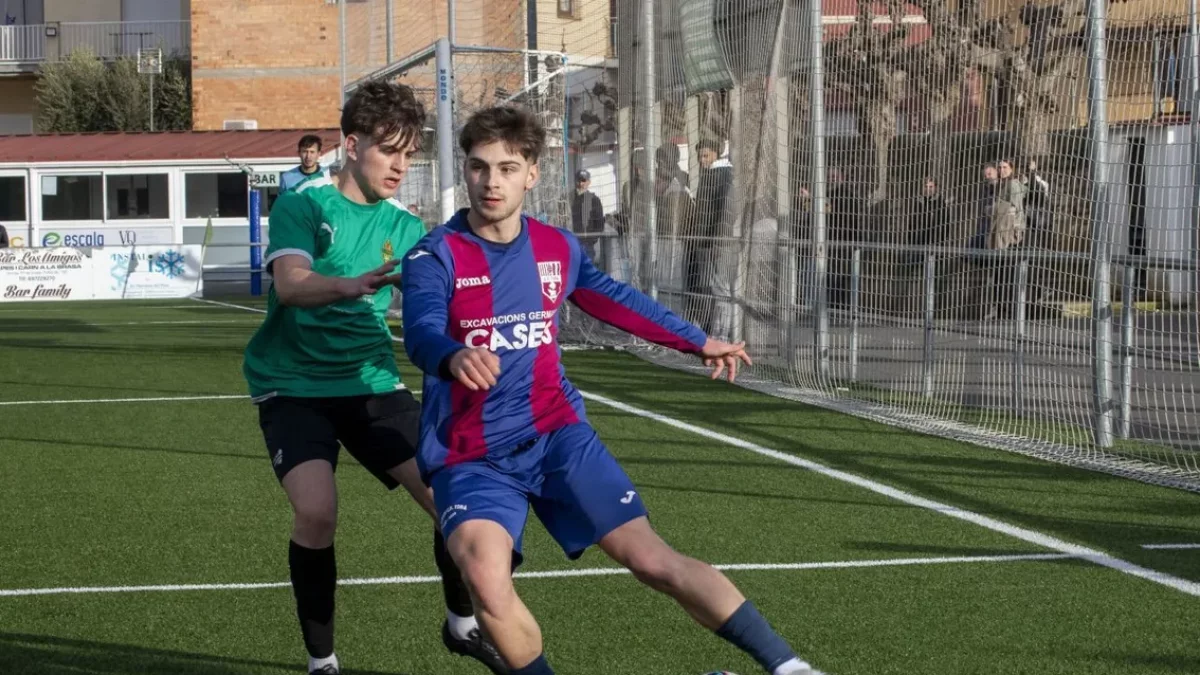 Un futbolista del Torà busca algun company mentre el pressiona un oponent del Cervera. - LAIA PEDRÓS