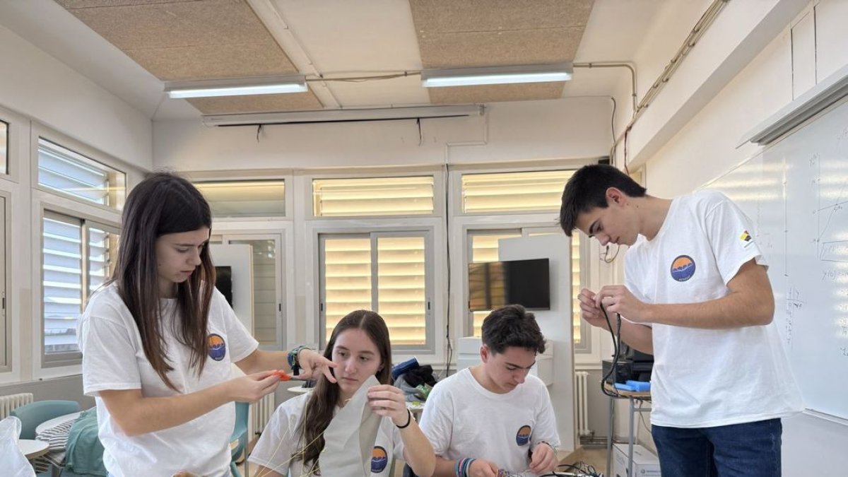 Los cuatro alumnos del Instituto de Tremp, acabando de confeccionar el cohete con el que se presentarán al concurso. - ACN