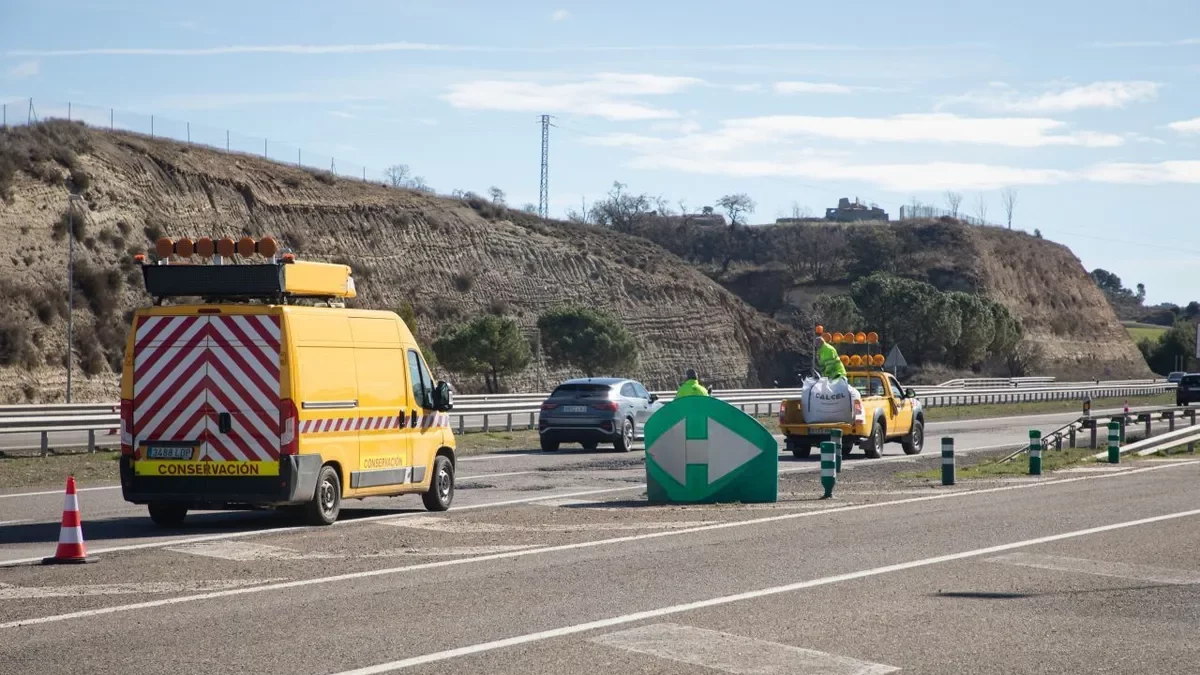 Operaris escampen asfalt a la zona on es van obrir els clots divendres passat. - JORDI BONILLA