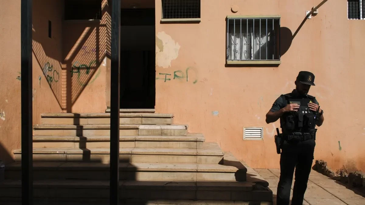 Un agent davant l’entrada de l’habitatge on es va cometre el crim. - EFE