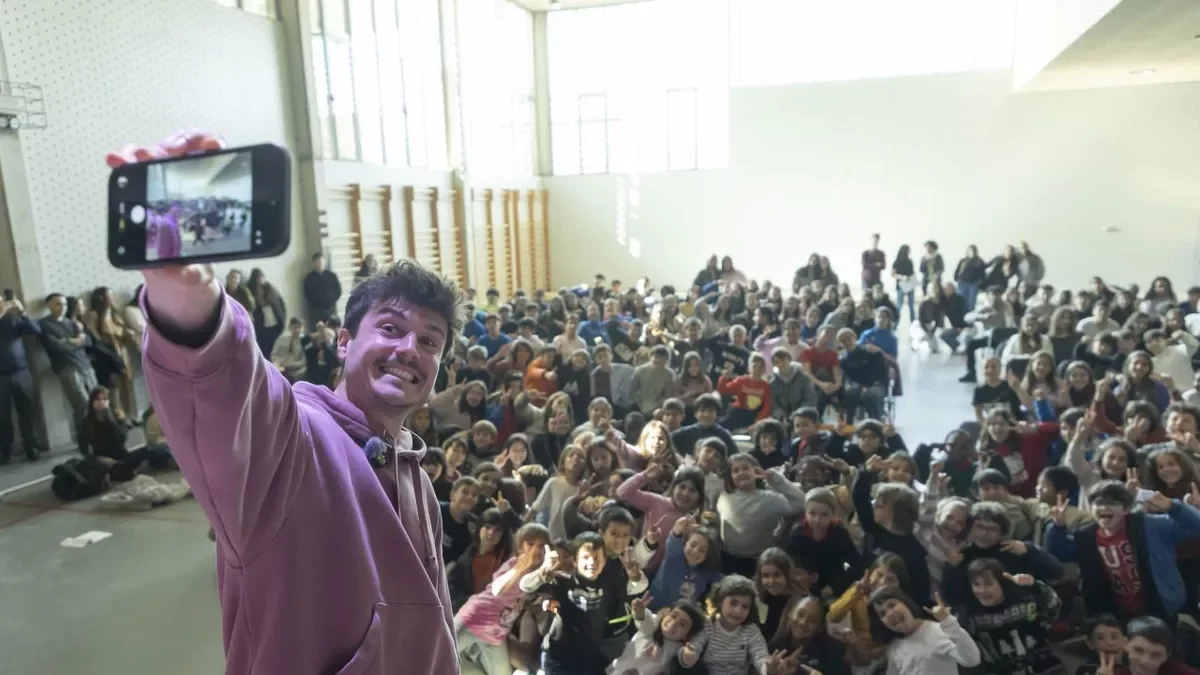 El cantante, sacándose una foto junto a los alumnos de la Escola Sant Jordi de Lleida. - J.GÓMEZ