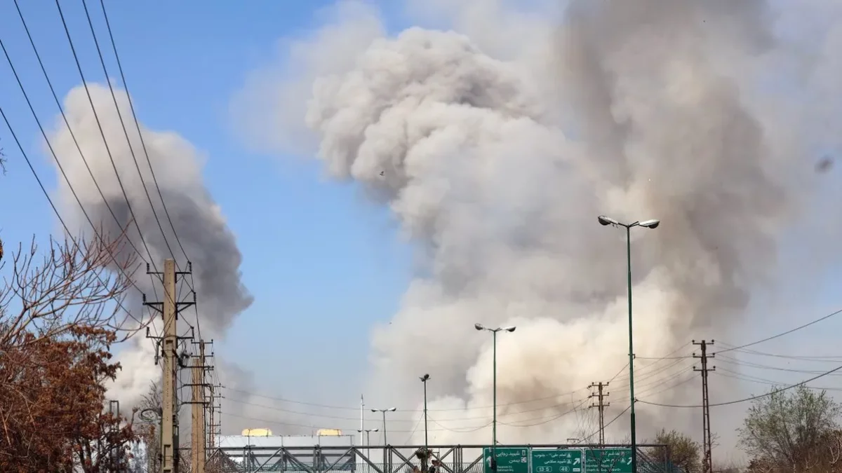 La gent corre a la recerca de refugi mentre el fum s’eleva després d’un atac aeri a Teheran, a l’Iran. - EFE/ ABEDIN TAHERKENAREH