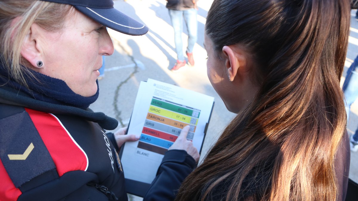 Una aspirant al cos dels Mossos d'Esquadra i una agent consultant l'aula on ha de fer les proves.
