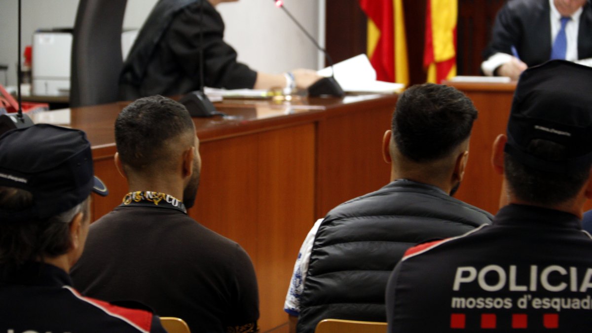 Els dos homes jutjats per introduir més de 13.000 pastilles d'èxtasi a l'estat espanyol, durant el judici a l'Audiència de Lleida el juny del 2025, custodiats pels Mossos d'Esquadra.