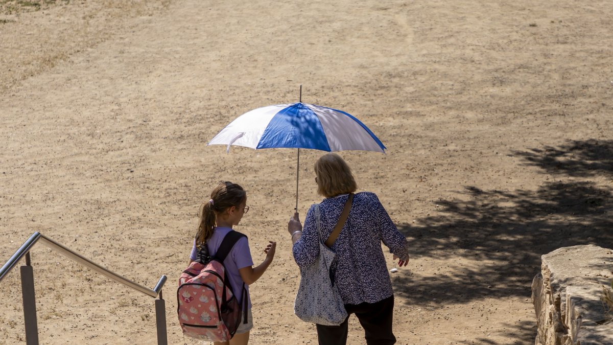 Persones amb parasol en un parc de Lleida.