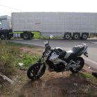 Estat en el qual va quedar la moto i, al fons, el camió implicat.