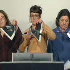 Imagen de televisión de varias diputadas de la CUP en el Parlament que rompen fotografías del Rey, durante una rueda de prensa.