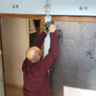 Un operario, colocando una plancha de metal en una puerta de uno de los pisos desalojados.