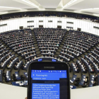Una persona mostra un SMS amb informació de "roaming" al seu telèfon mòbil durant el ple del Parlament Europeu a Estrasburg (França)