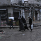Varias personas caminan por las calles de Alepo en zona aún controlada por los rebeldes.