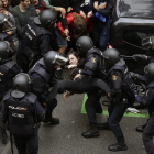 Los agentes de la Policía Nacional forman un cordón policial en el colegio Ramón Llull y se llevan a una chica.