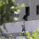 Policías iraníes ayudan a escapar a civiles después de que hombres armados entraran en el Parlamento.