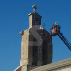 Els bombers, al campanar de la l'església de Sant Martí per rescatar una cigonya atrapada.