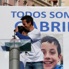 Los padres de Gabriel, abrazándose delante de una fotografía del menor en un acto el pasado viernes y, a la derecha, la detenida, Ana Julia Quezada.