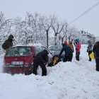 Afectats per la intensa nevada a Bellver de Cerdanya provant de col·locar cadenes als vehicles.