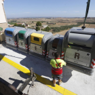 Operaris instal·lant els contenidors de recollida selectiva al costat dels vells en una de les illes delimitades per l’ajuntament d’Alfés.