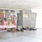 Un grup d’immigrants dormint a la part ombrejada del centre cívic de plaça l’Ereta, ahir.