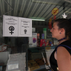 Un mujer mira ayer uno de los carteles colgados en un establecimiento de la calle Cardenal Remolins.