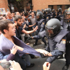 Un policía carga contra un joven ante el colegio de la Mariola. 