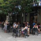 Imagen de una terraza de un bar con clientes junto a la plaza Sant Joan de Lleida ciudad.