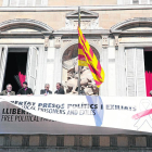 Operarios del Govern instalando la nueva pancarta sobre la antigua, ayer en Barcelona.