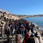 Un grup de persones proven de creuar la tanca fronterera que separa Fnideq (Castillejos, Marroc) i Ceuta aquest dimecres.