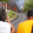 Dos persones observen la lava avançant per la zona de Cabeza de Vaca a El Paso, La Palma.
