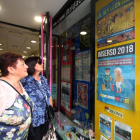 Dos mujeres observan el cartel del Imserso en la agencia de Iltrida de la calle Sant Antoni.