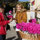 Una dona col·labora amb la iniciativa ‘Una flor per a un projecte’ a la taula de Ricard Viñes.