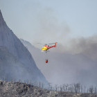En el incendio de Peramola trabajaron ayer 55 dotaciones terrestres y 9 aéreas. A la derecha, jóvenes contemplando el humo.