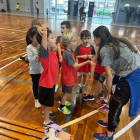 Una entrenadora del Lleida Handbol Club dona instruccions al seu equip de nens i nenes.