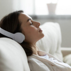 Una mujer durmiendo mientras escucha música con auriculares.