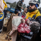 Membres dels Cascos Blancs sirians porten el cos d’una nena d’un edifici destruït a Harem, a prop de la frontera amb Turquia.