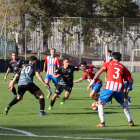 Nil Sauret intenta controlar una pilota envoltat de jugadors del Girona i al costat de Jordi Puig.
