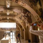 Un visitant, fent fotos dels murals de Sixena al MNAC. - KIKE RINCÓN / EUROPA PRESS