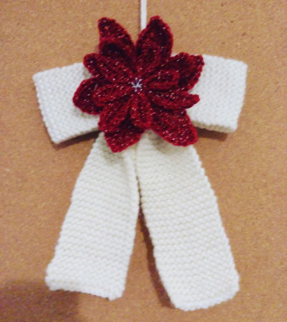 Ornament nadalenc. El llaç ha estat teixit amb dues agulles i la flor de Nadal (o Poinsettia) s'ha realitzat amb ganxet.